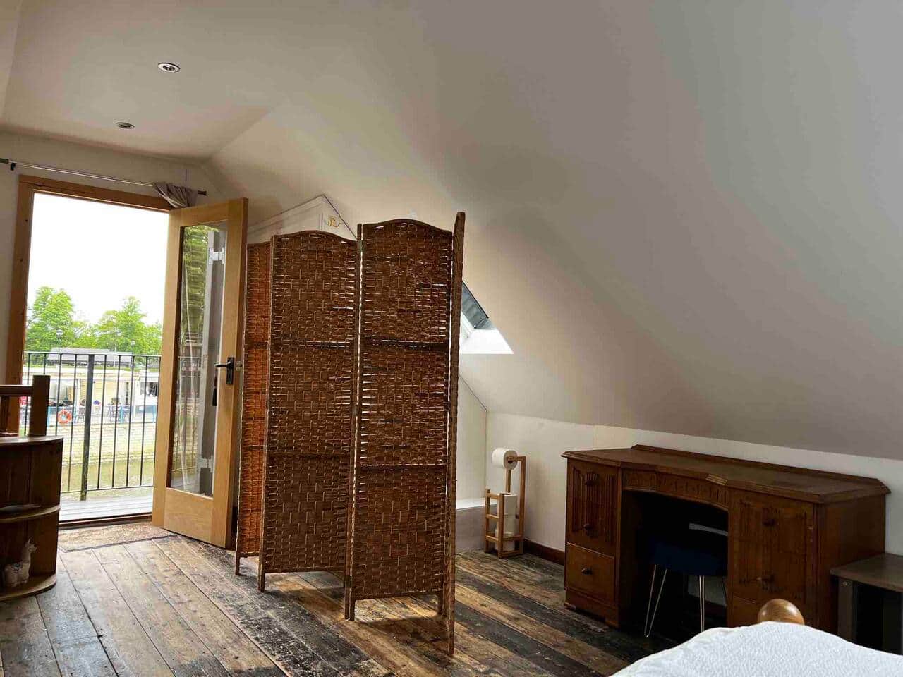 The bedroom on the first floor hosts a toilet which is obscured by a screen. 