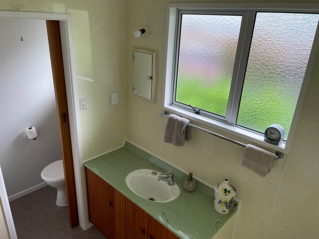 Bathroom 1: 1950's melamine walls and 1970s avocado sink! Separate toilet.