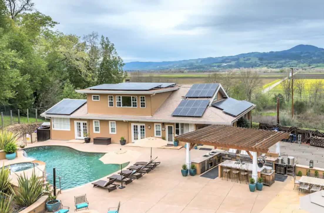 A resort backyard with pool, hot tub, kitchen, many places to relax, underneath your own vineyard
