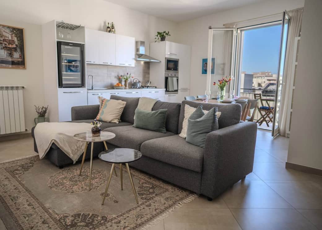 Bright and airy, the open-plan living room is filled with natural light from the balcony doors
