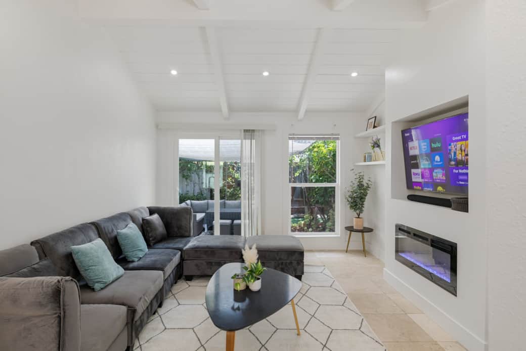 Step into our modern living room with plenty of natural light, featuring a sleek  media wall