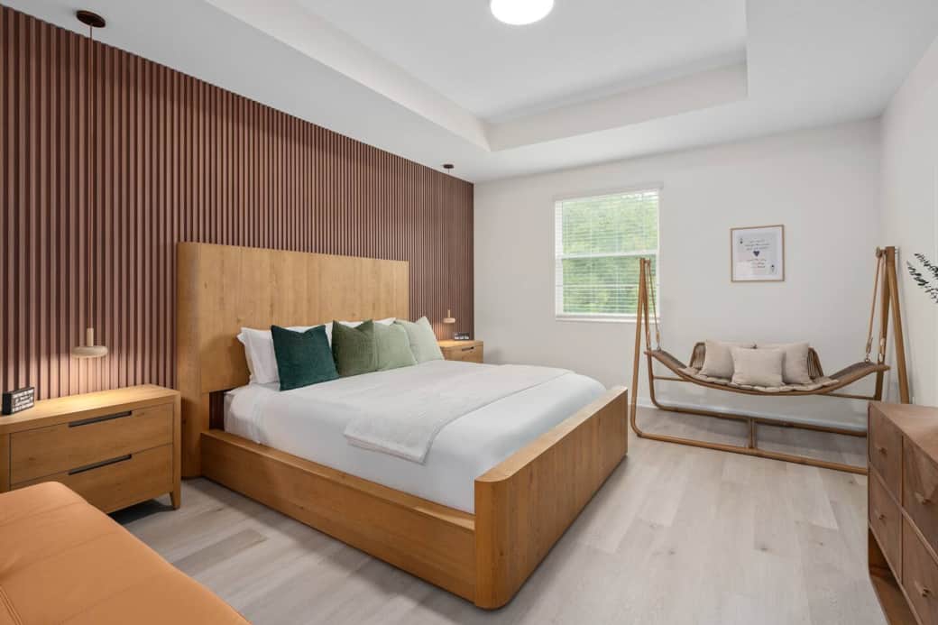 California king bed with a supportive, comfort-focused mattress for quality sleep-Blackout shades to encourage deep rest-Wood tones and calming green accents inspired by nature-Hotel-like design that creates a soothing retreat for parents