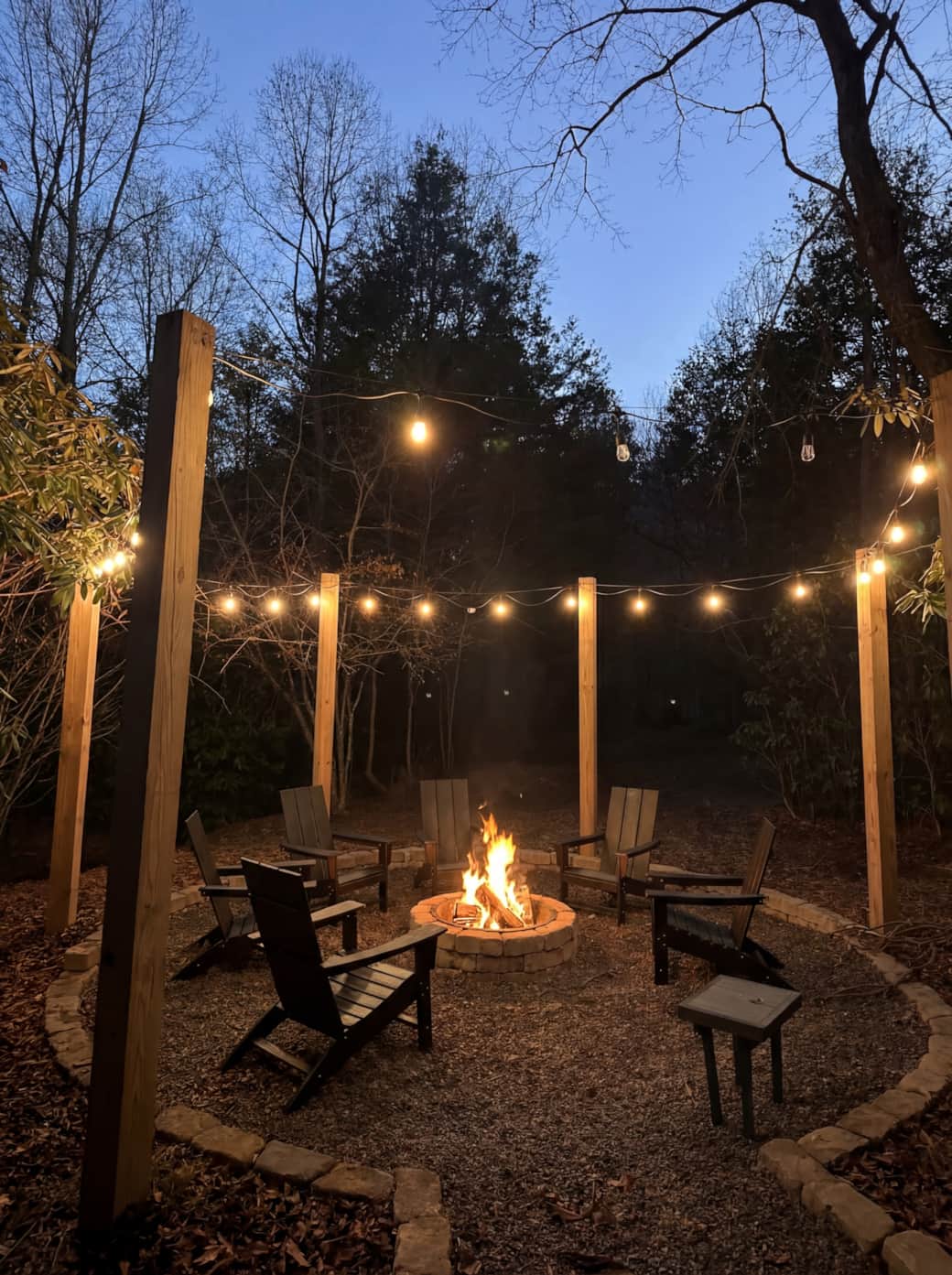 Cozy firepit area with string lights under the stars.