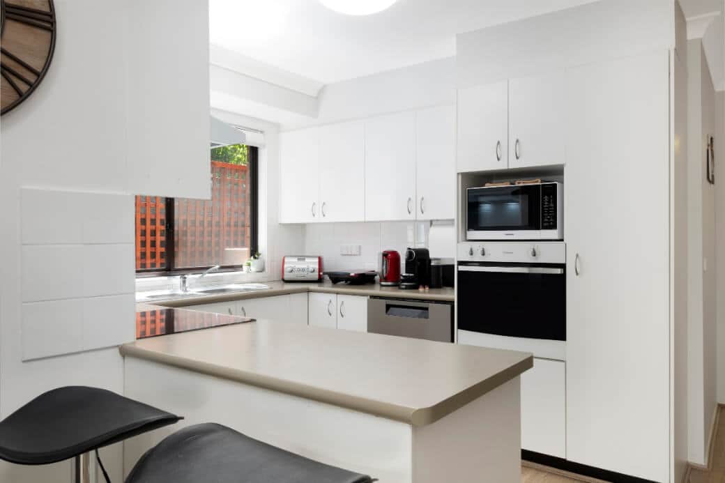 Fully equipped kitchen including dishwasher and fridge, shares the same room as the dining area. 