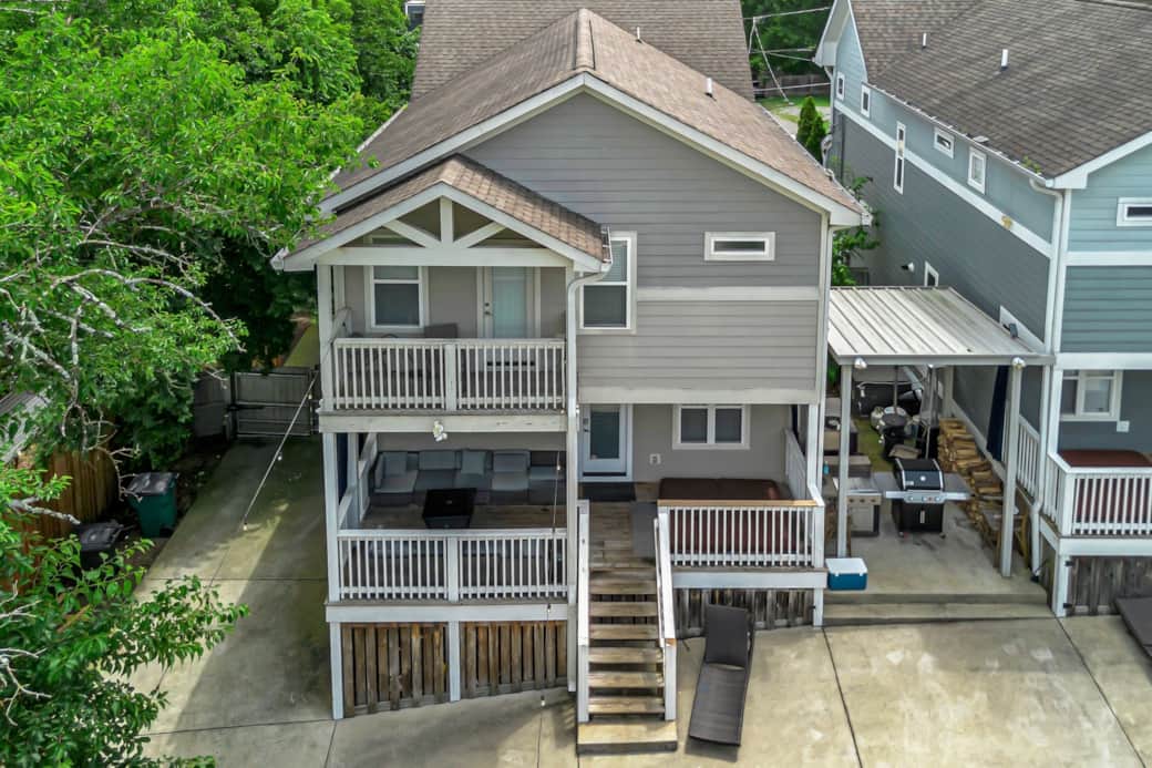 Driveway wraps around back with 2 story decks and covered grill area, hot tub, outdoor TV firepit