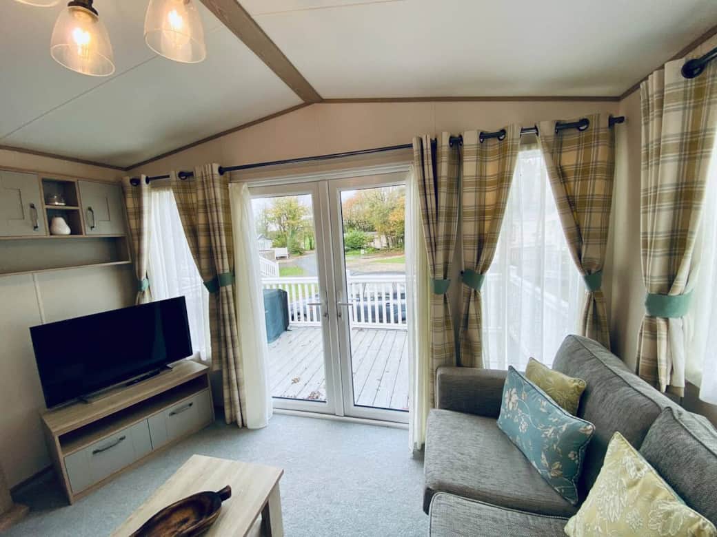 living room with patio doors onto the outdoor decking area with furniture 