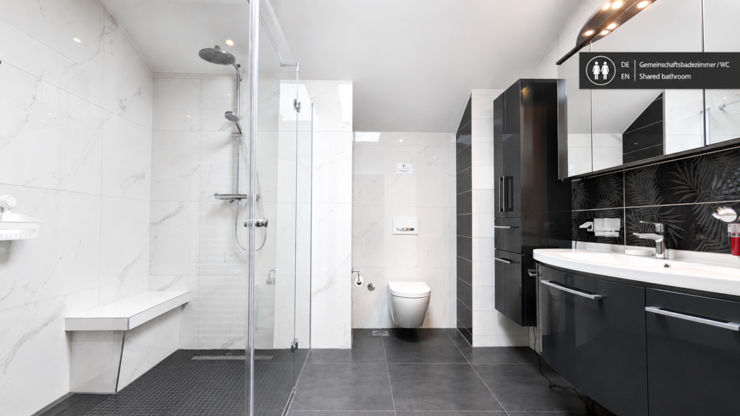 Großzügiges Gemeinschaftsbad mit ebenerdige Regendusche sowie Fußbodenheizung