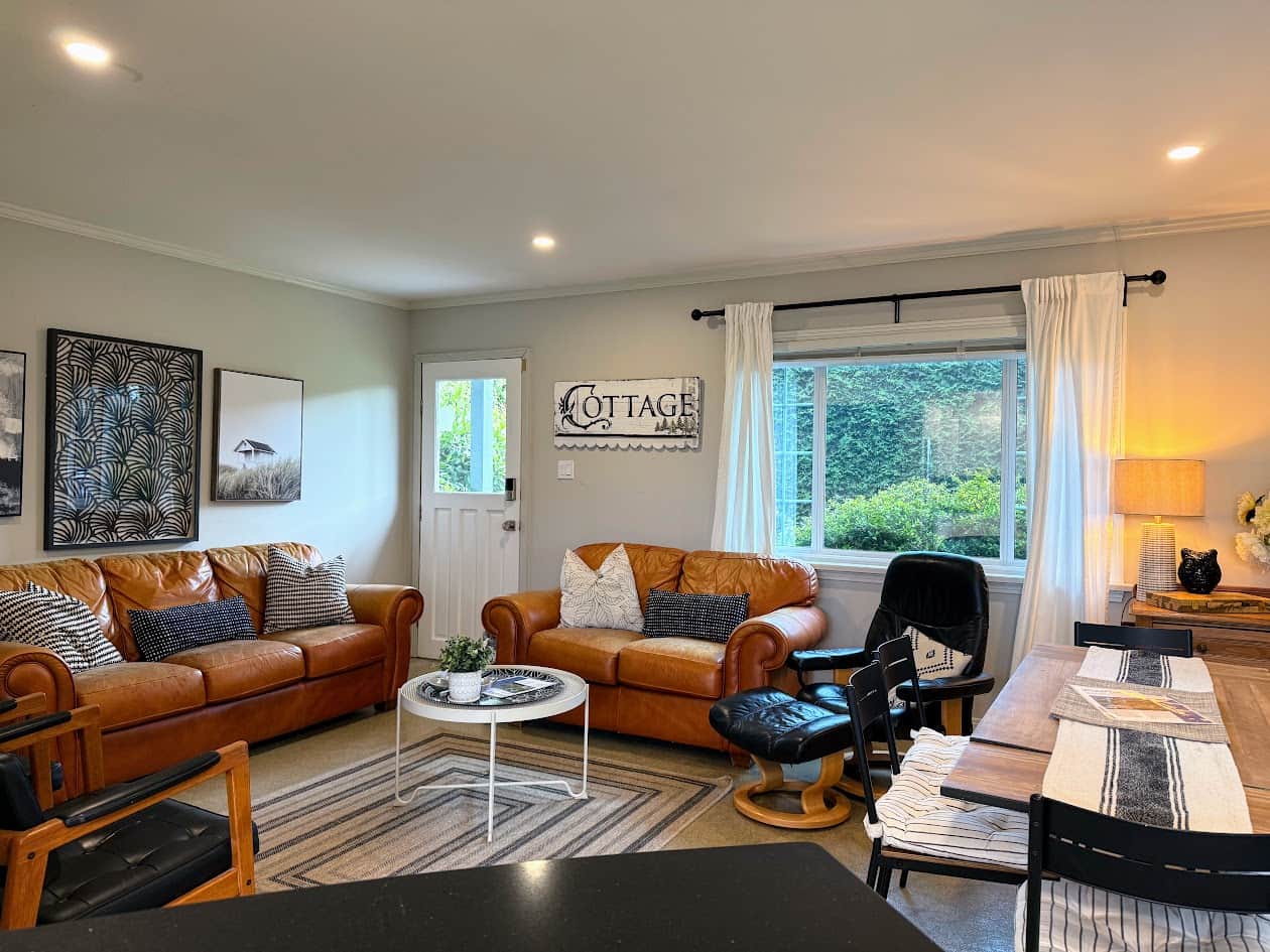 Cozy living/dining room with comfy leather seating, dining for 6, wall mounted Smart TV.
