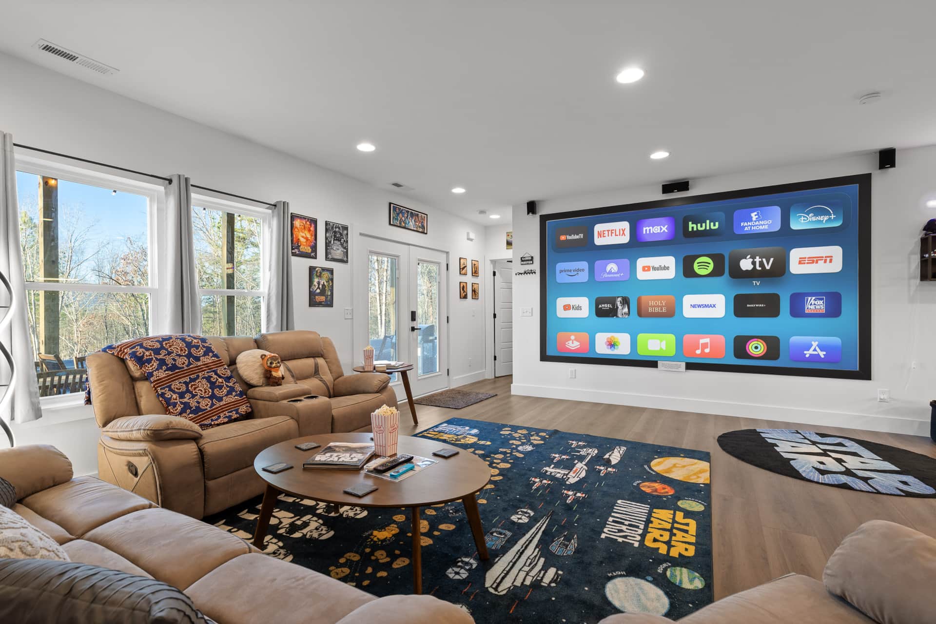 A cozy themed movie theater inside a luxury cabin with reclining seats and a large screen.