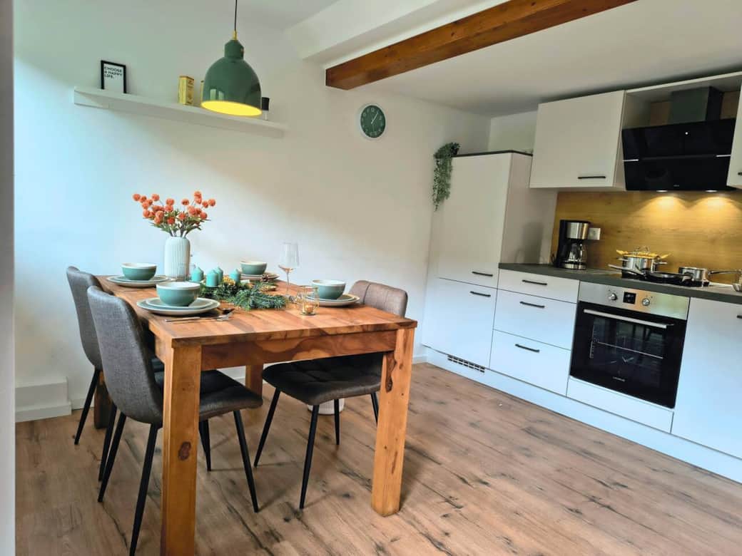 Gemütliche Wohnküche mit großem Holztisch und voll ausgestatteter Küchenzeile – ideal für gemeinsame Mahlzeiten und lange Abende im Harz. Gemütliche Wohnküche mit großem Holztisch und voll ausgestatteter Küchenzeile – ideal für gemeinsame Mahlzeiten und lange Abende im Harz.