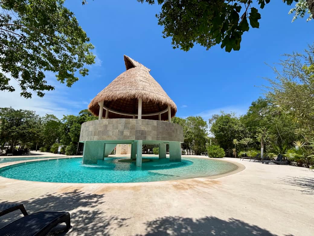 Common area with pools, palapas, hamocks, beach chairs and  tropical garden