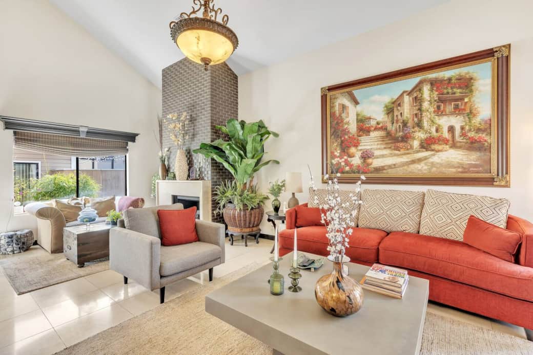 Stylish living space with red sofa, indoor plants, and modern fireplace.
