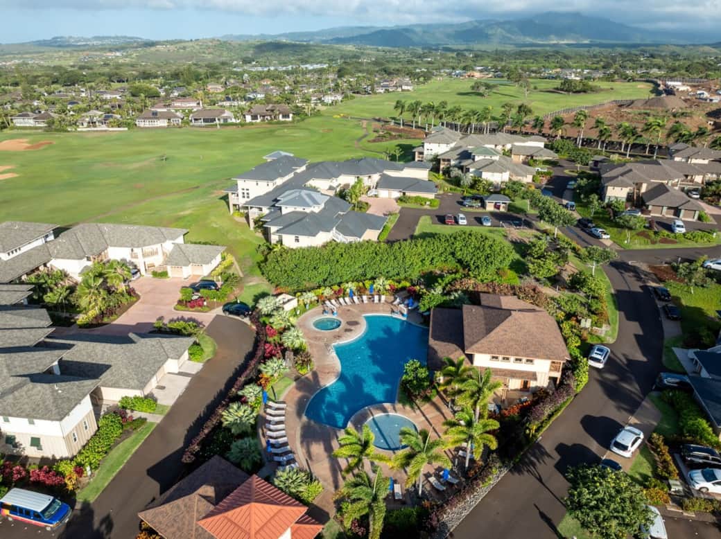 Aerial view of Pili Mai resort — pool, spa, children's pool, and Kiahuna Golf Course with mountain v