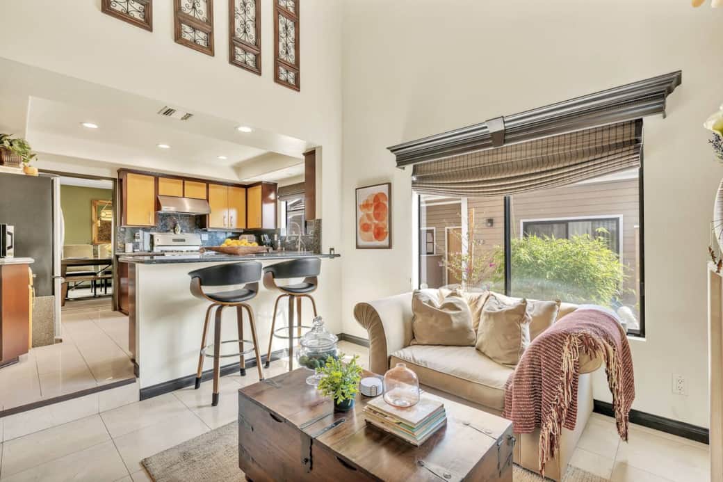 Open-concept kitchen with island seating, modern stools, and natural light.
