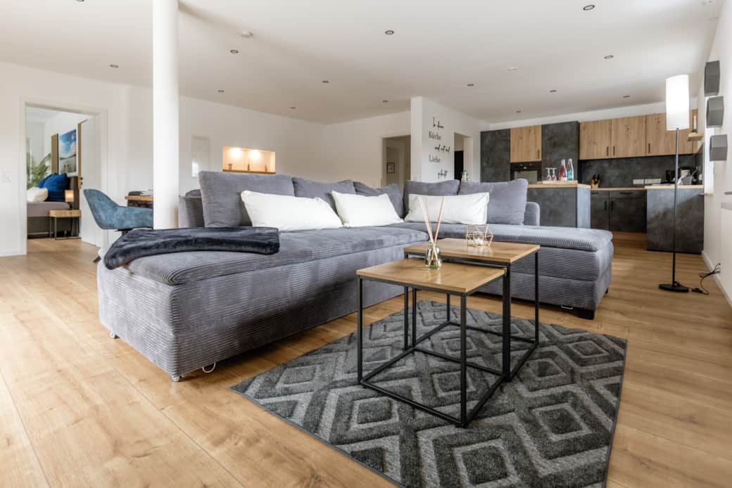 Wohnzimmer mit Boxspring-Couch, Smart-TV und Spielesammlung, Kniffel und Karten.
