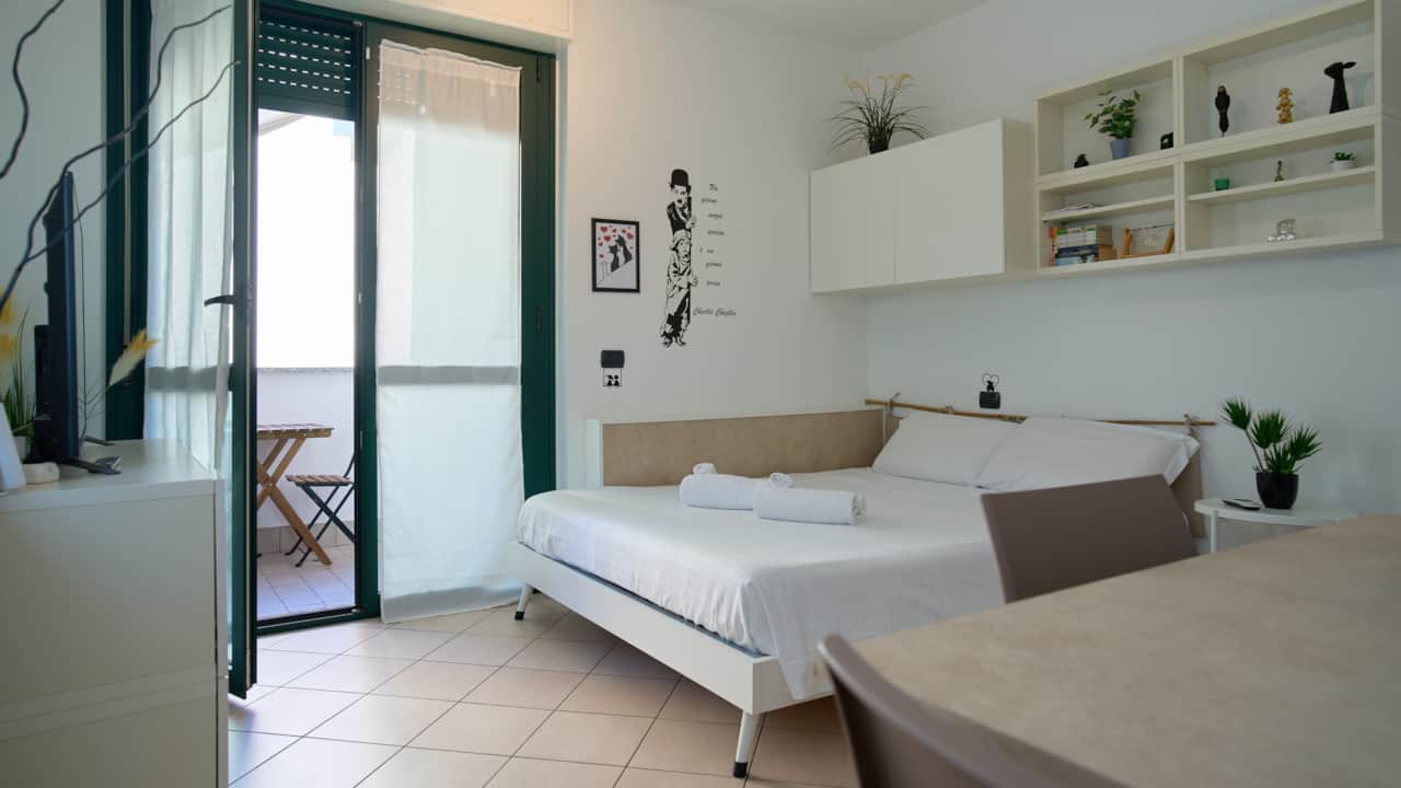 Chambre avec porte ouverte sur le balcon