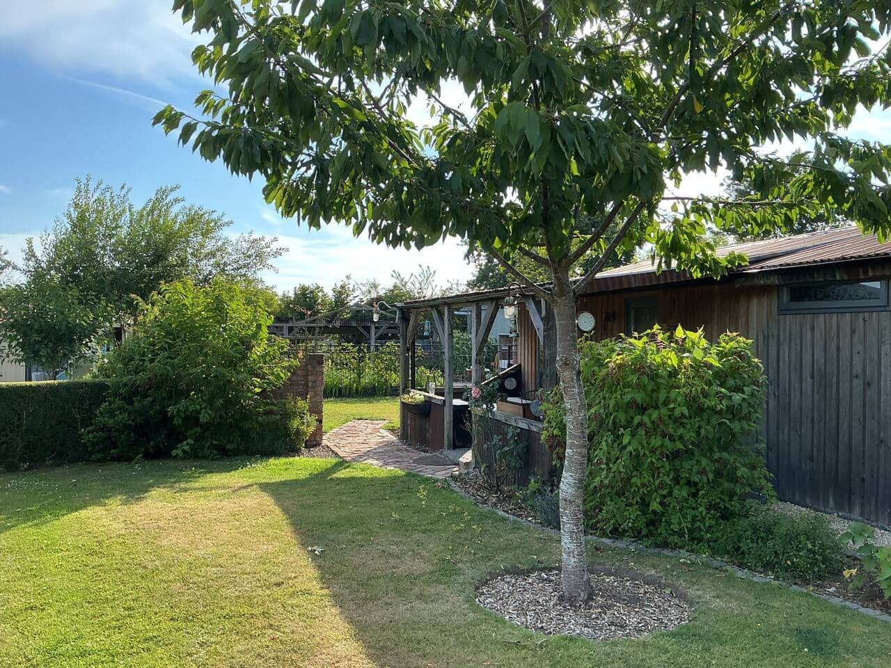 The front garden of The Stables Hut has grass and a hedge.