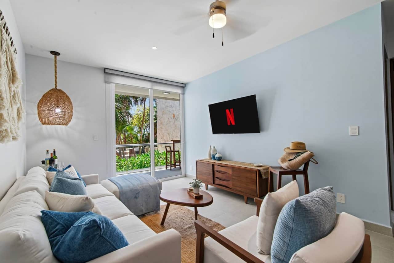 Relax in the inviting living room with ocean views, a comfy couch, Smart TV for streaming your favorite shows, air conditioning, a ceiling fan, and room-darkening shades. Enjoy direct access to the private balcony with a hot tub and garden.