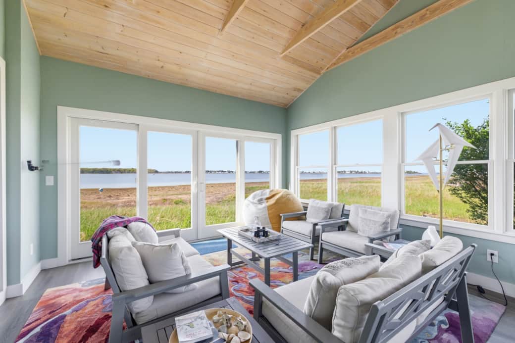 The large sun room features large windows and a sliding door to enjoy the breeze.