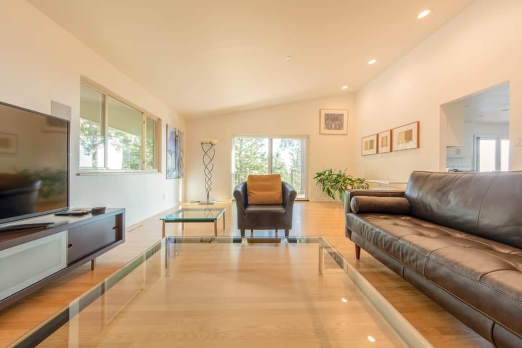 Enjoy spending time in this spacious, bright living room with a large high-definition smart TV and lounging in the new 2021 leather couch and chairs.