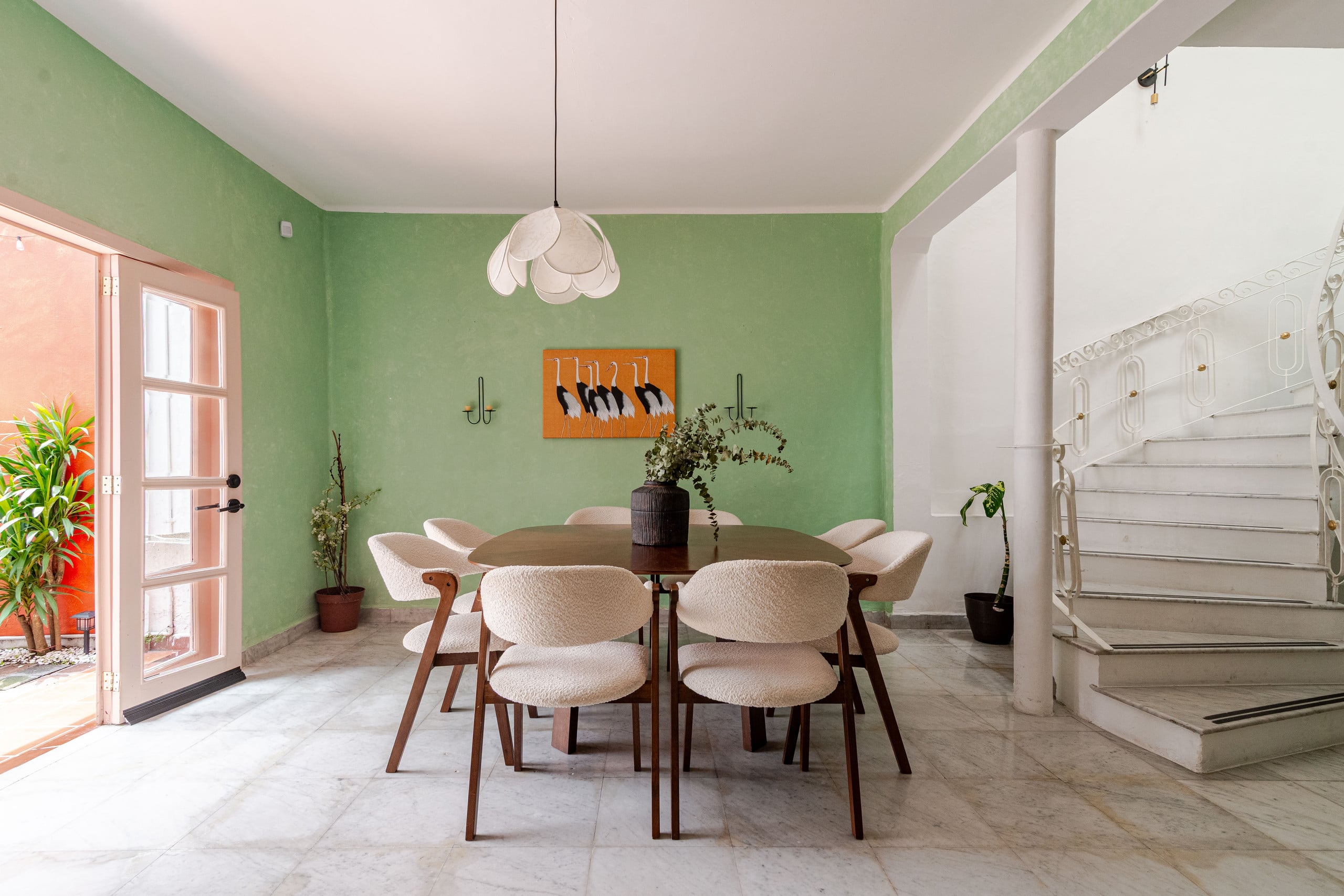 Dining room with a long wooden table and green walls at Casa Atlixco