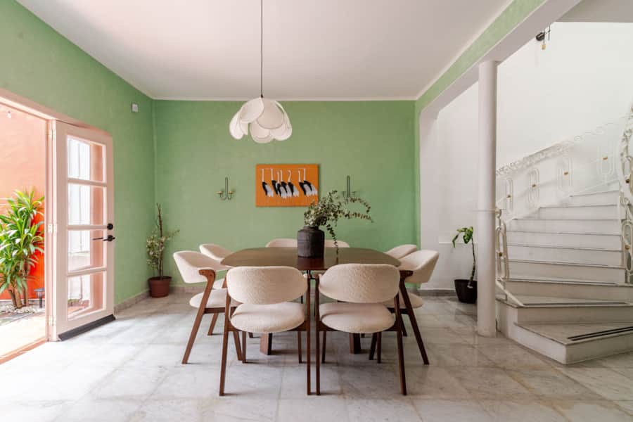 Dining room with a long wooden table and green walls at Casa Atlixco