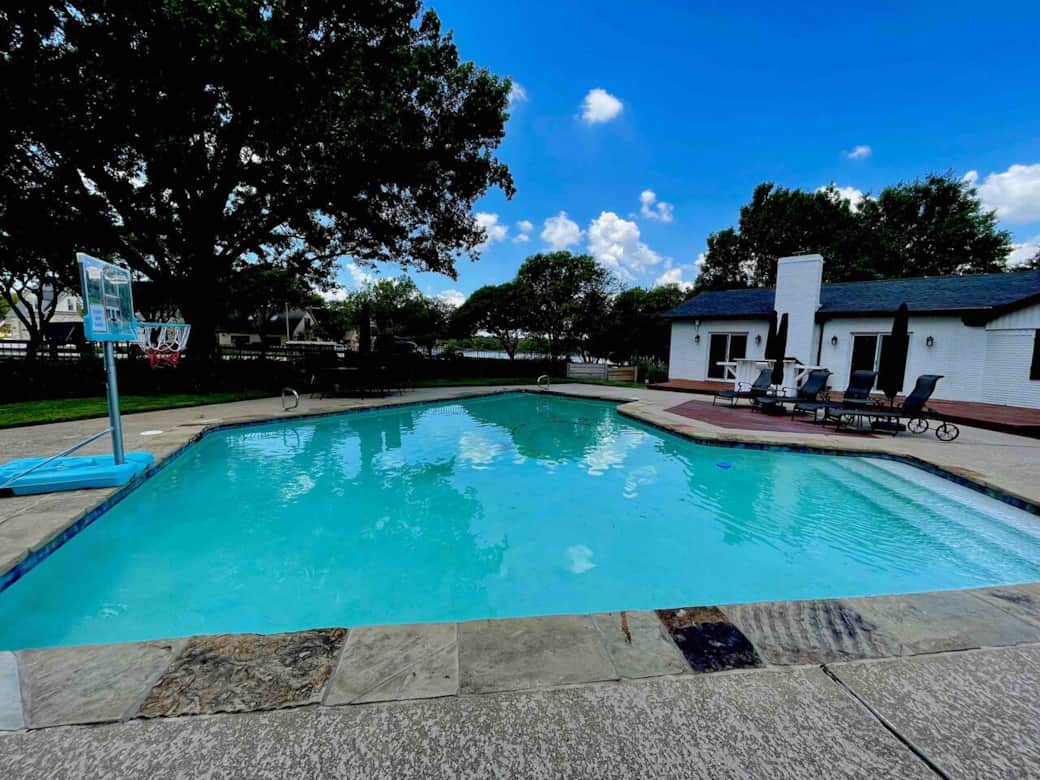 Pool basketball, lay out chairs with umbrellas and an outdoor bar.