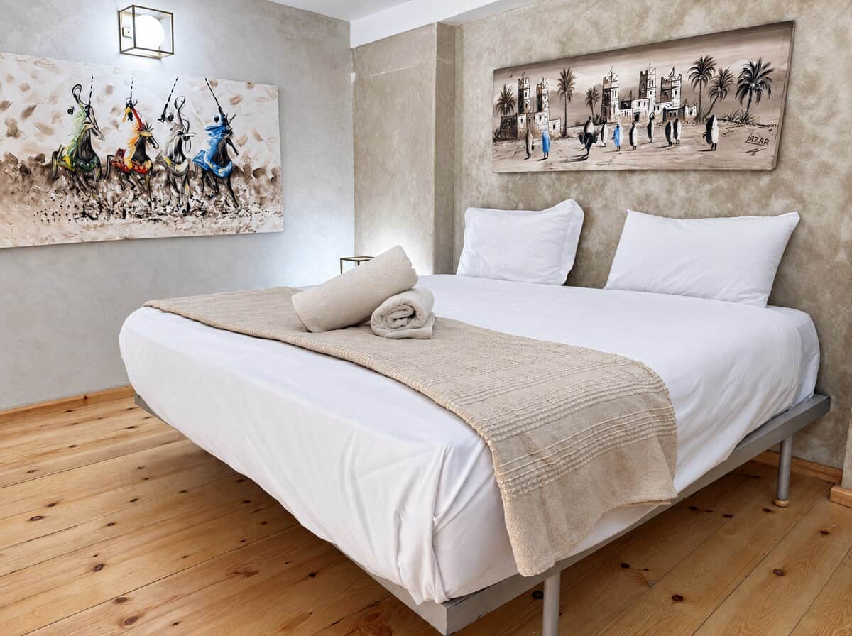 Chambre Jaune avec lit double, linge de maison soigné et décoration contemporaine.