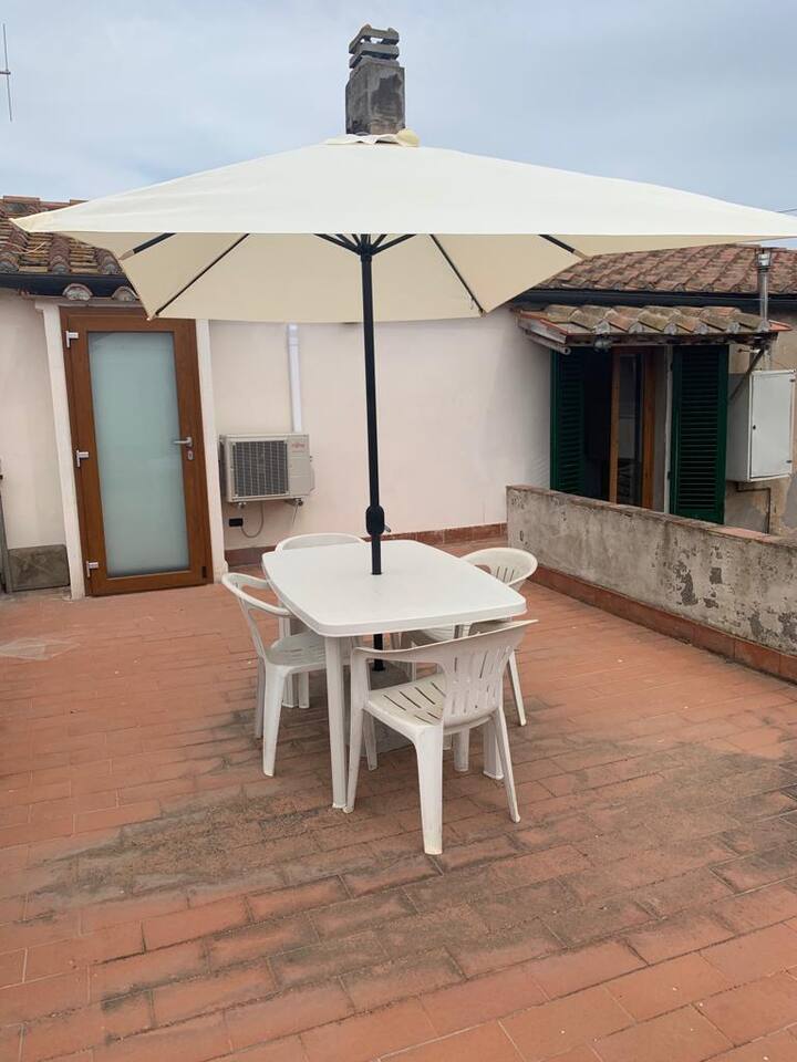 Terrazza con tavolo da pranzo e ombrellone