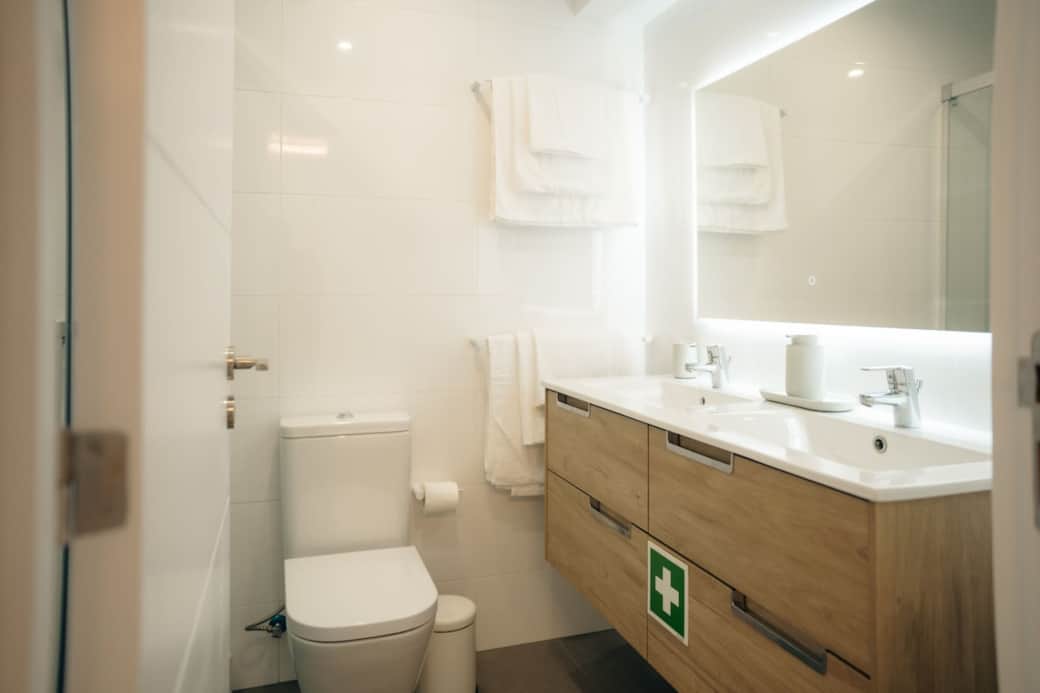 A bright, clean overview of the entire modern bathroom, featuring the spacious double vanity.