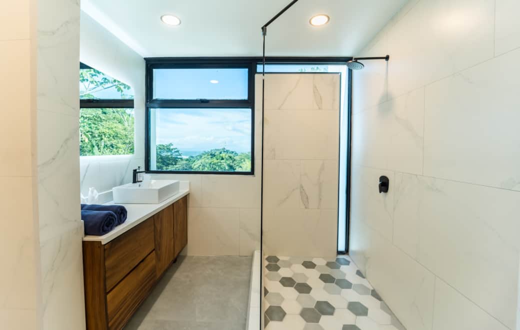 Bright modern bathroom with walk-in shower, sleek finishes, and natural light Bright modern bathroom with walk-in shower, sleek finishes, and natural light