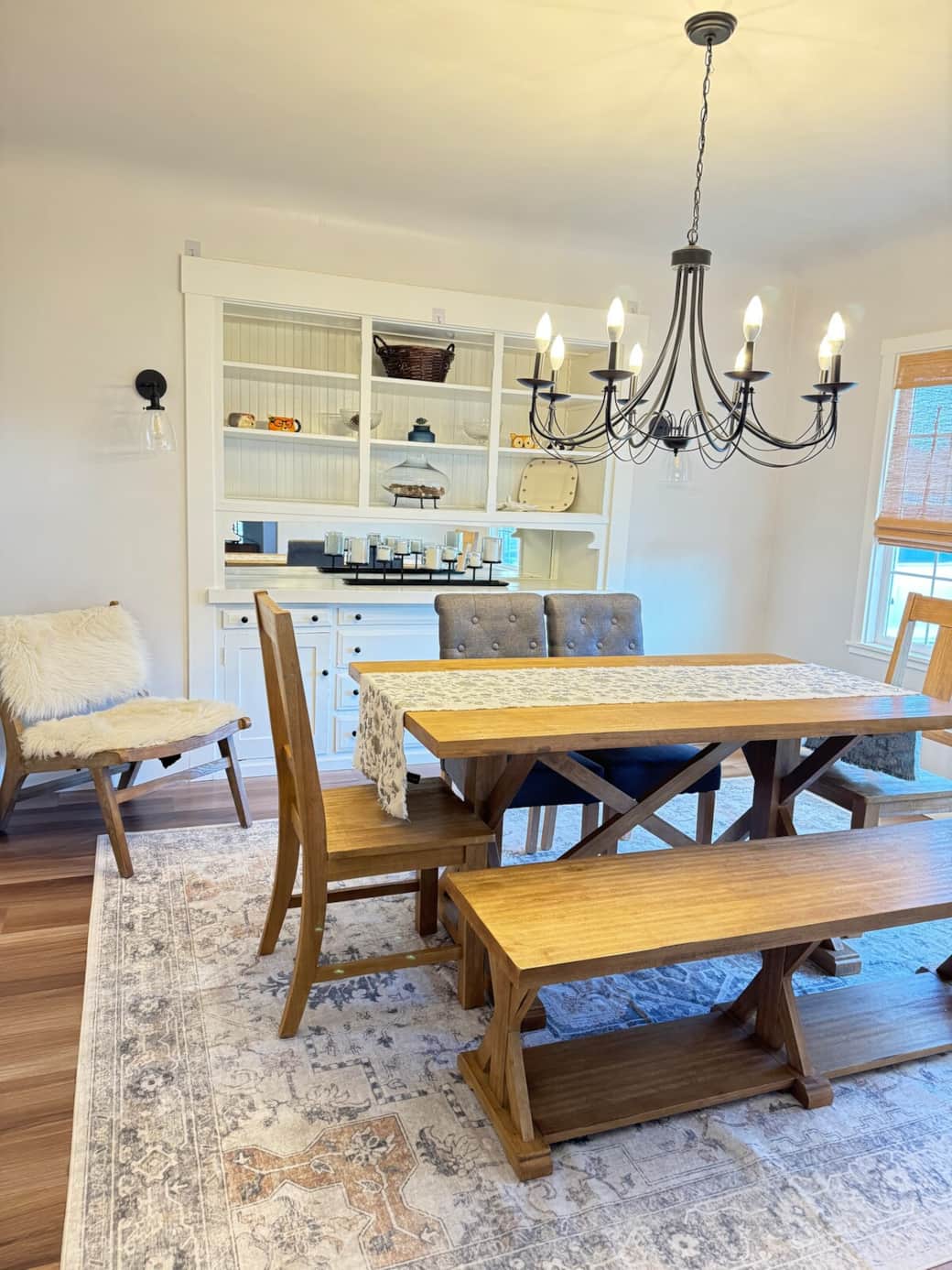 Spacious and bright dining room with beautiful solid wood table, bench, upholstered chairs, and elegant chandelier inviting space with lots of natural light with plenty of room for everyone! 
