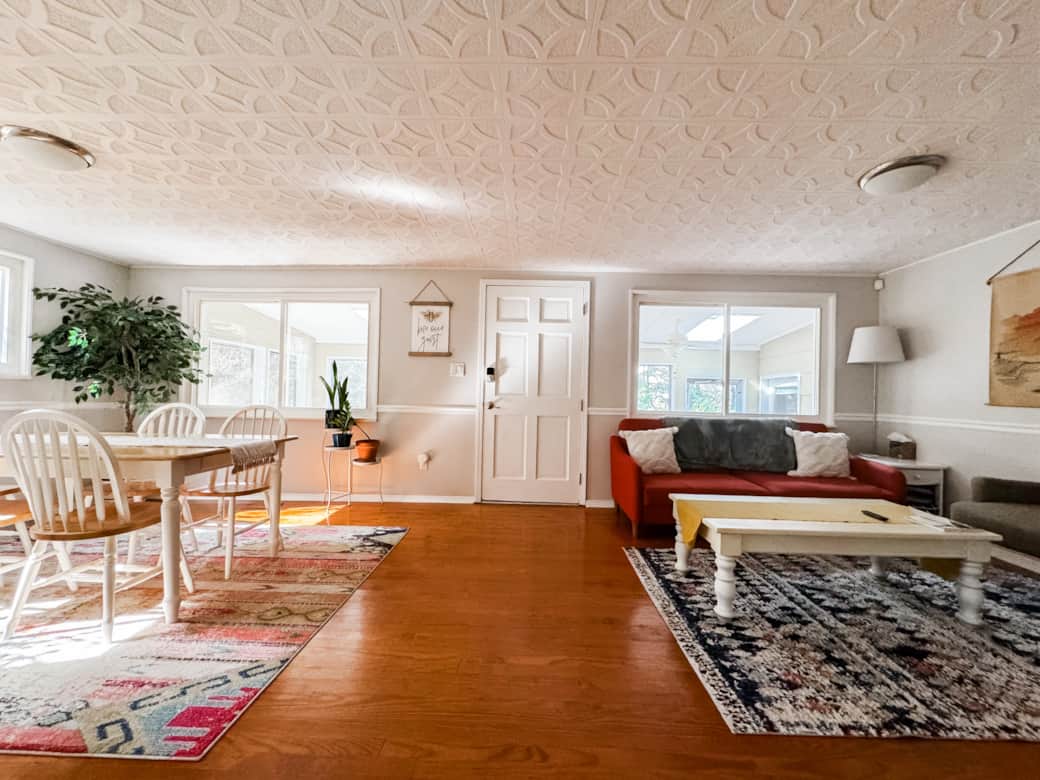 A view of the dining room and living room with the door to the sunroom.