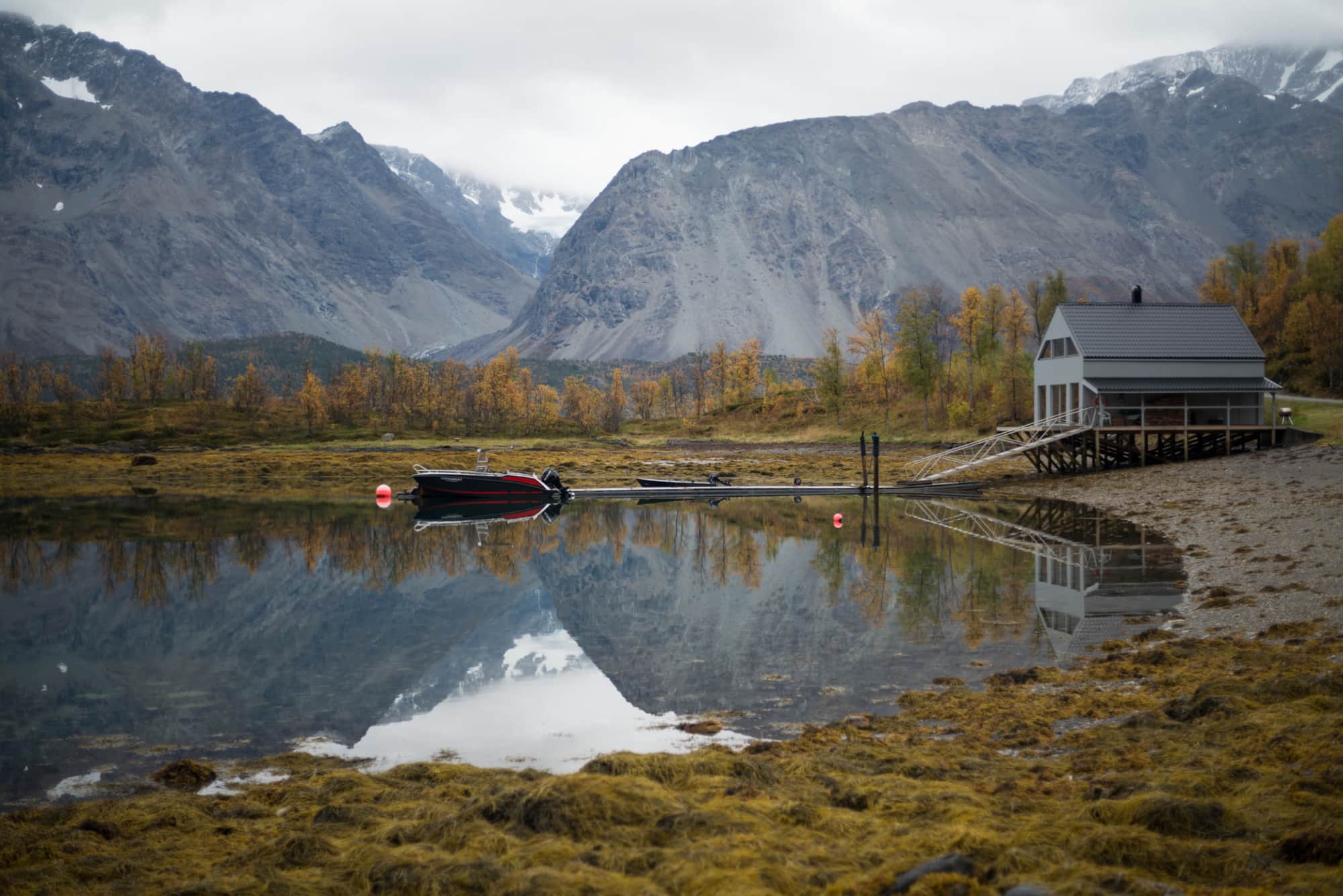 Boot am Steg vor Sommarbukt, dahinter die Lyngen-Alpen im Herbst