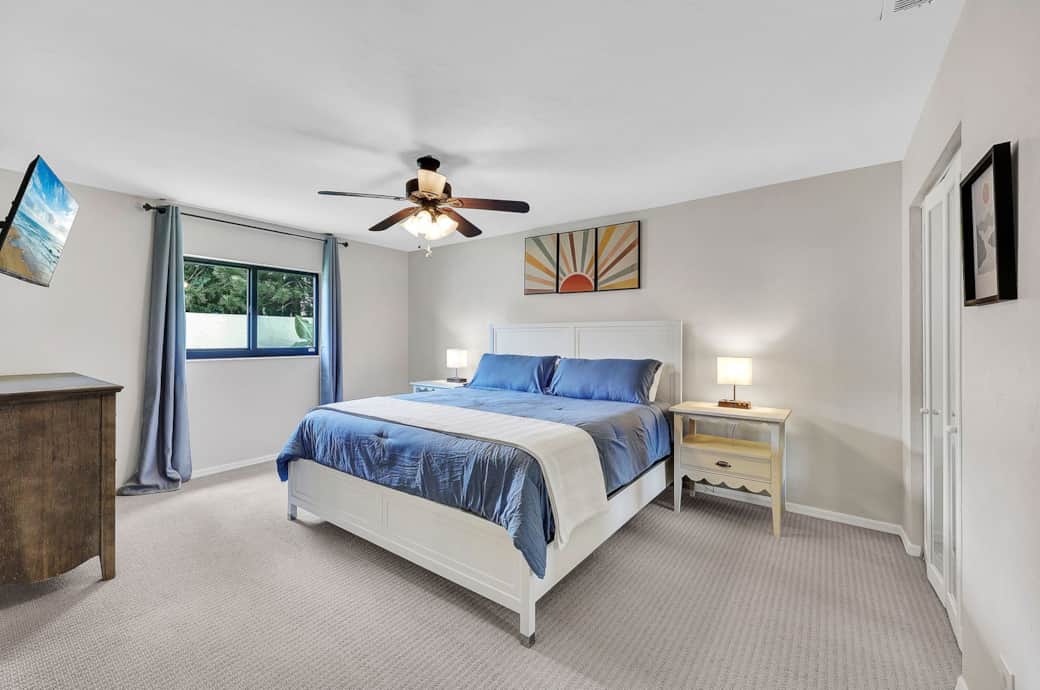 Spacious master bedroom with a king bed, a TV, and en suite master bathroom with a walk in shower. 