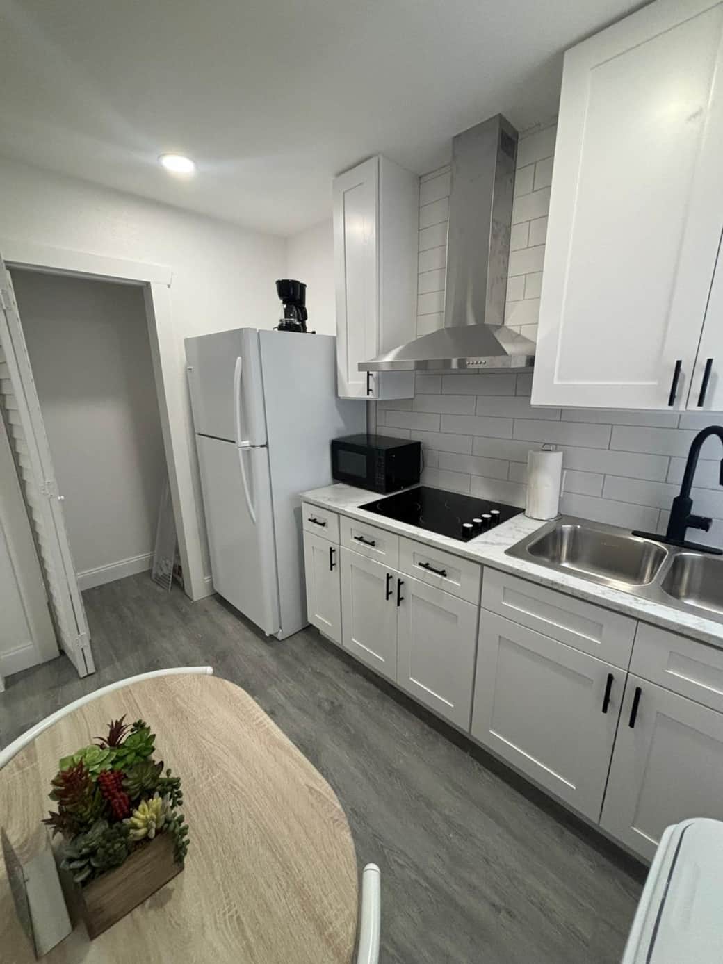 Fully equipped cozy kitchen with fridge, stove, cabinets, and hood. Lakeland, FL