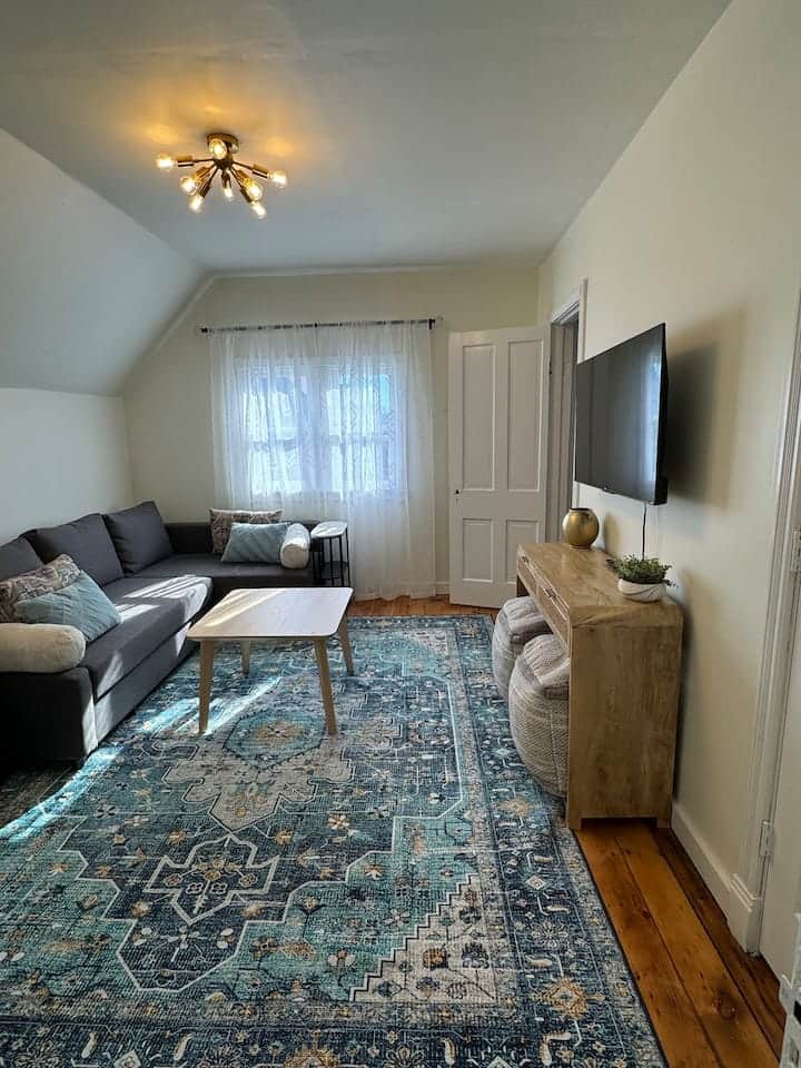 Cozy living area with a comfortable sectional, soft natural light, and a smart TV for relaxing night