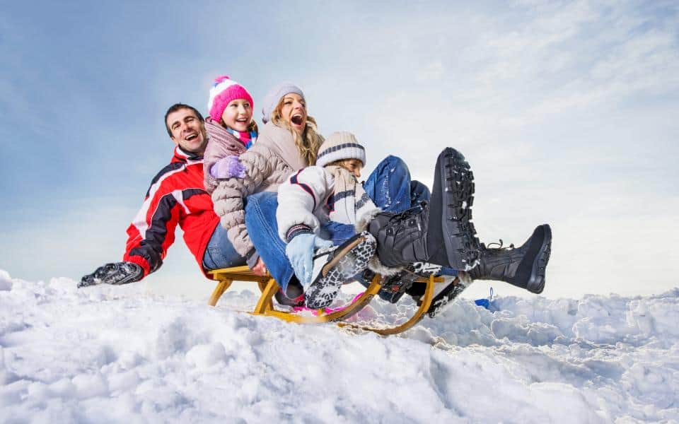Famille en luge sous la neige, fous rires et joie en hiver, Serre Chevalier Vallée
