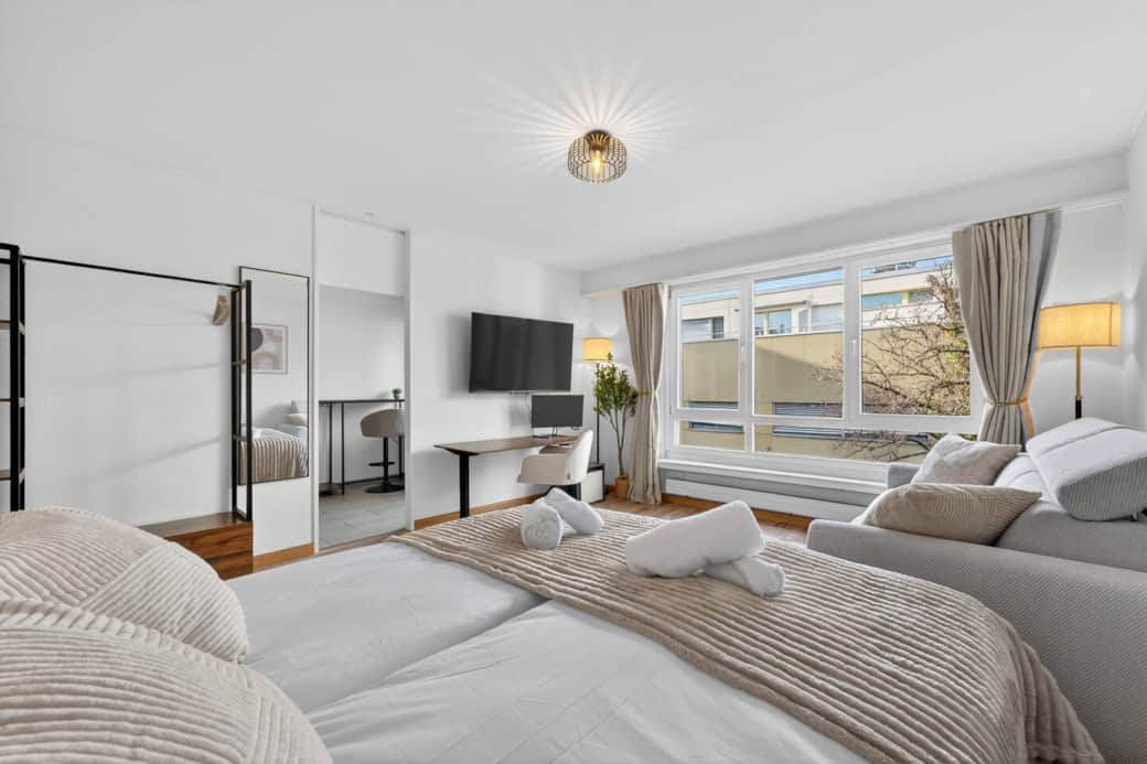 Bright, modern main room with 55" Smart TV + Netflix, workspace & large windows.