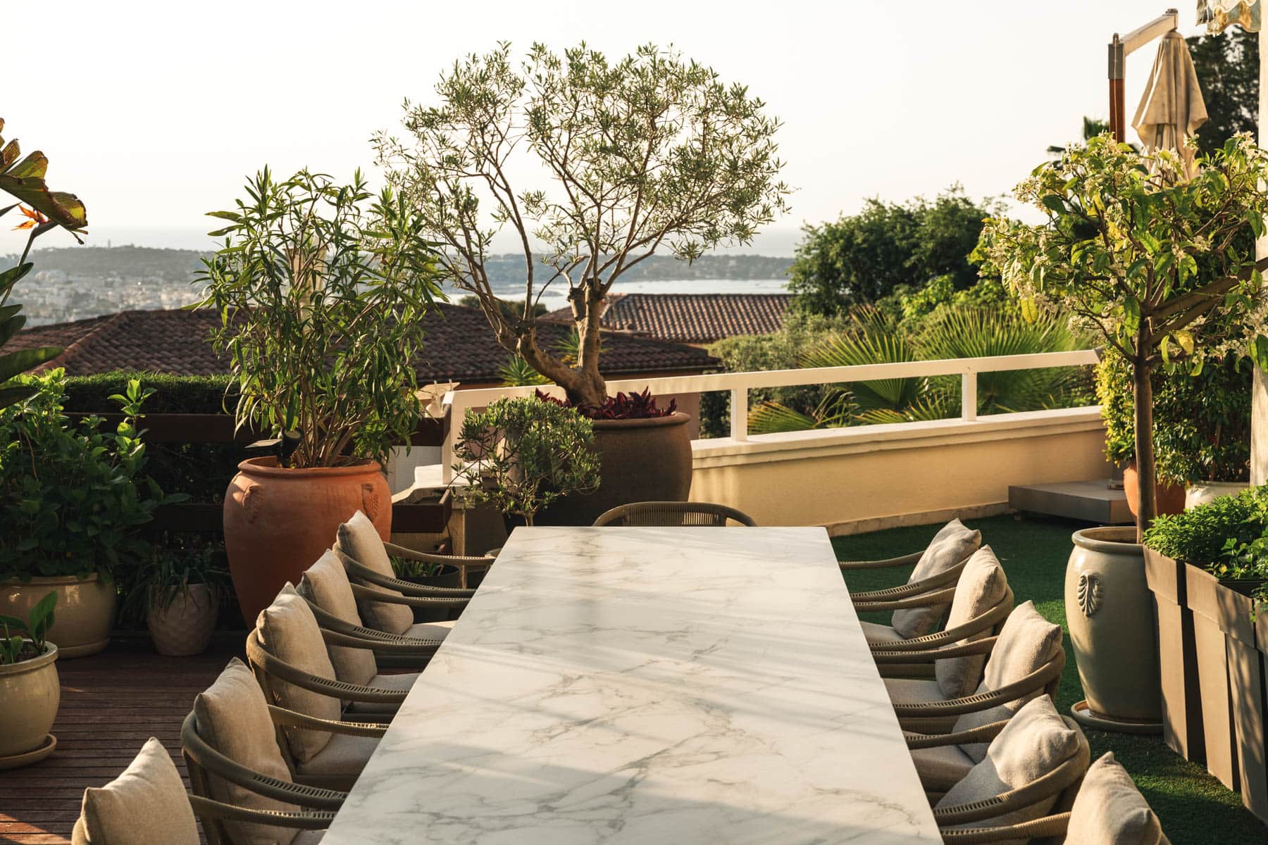 Garden terrace dining beneath palms and olive trees