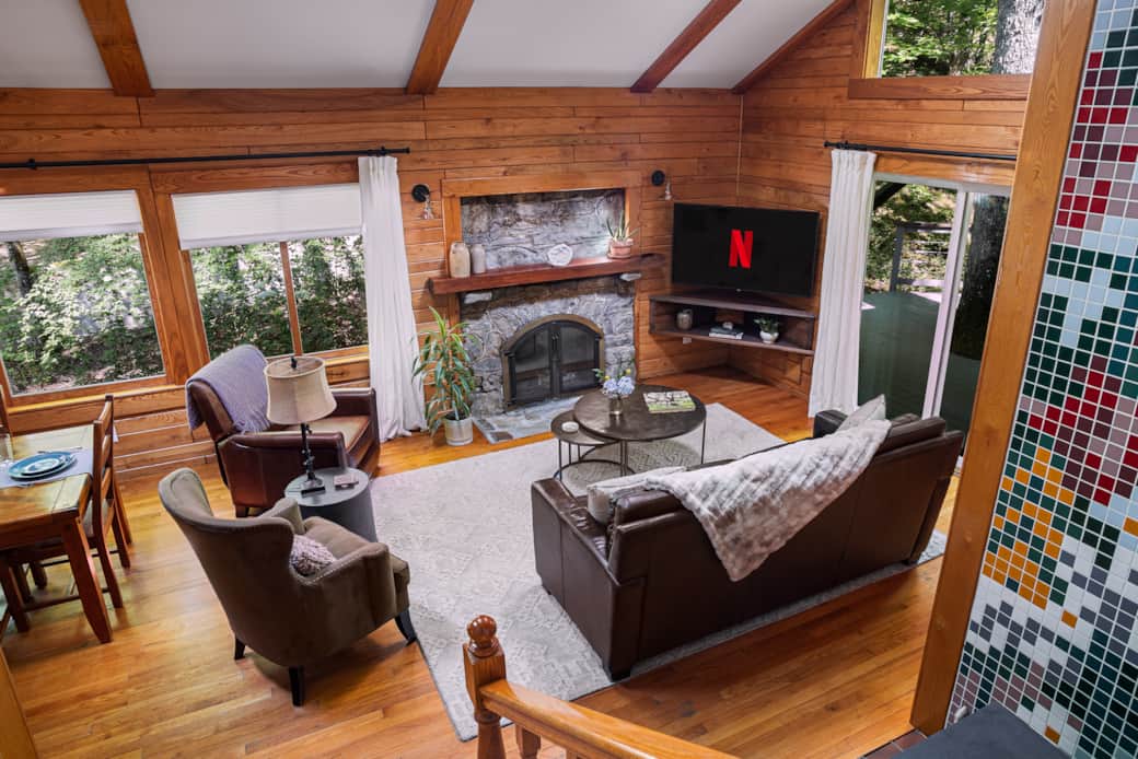 Cozy by the wood stove, enjoy a 55" smart TV, with skylights and sliding doors to the side deck.