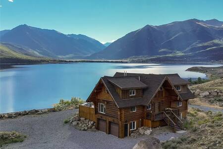Rustic log cabin overlooking mountain lake with scenic views