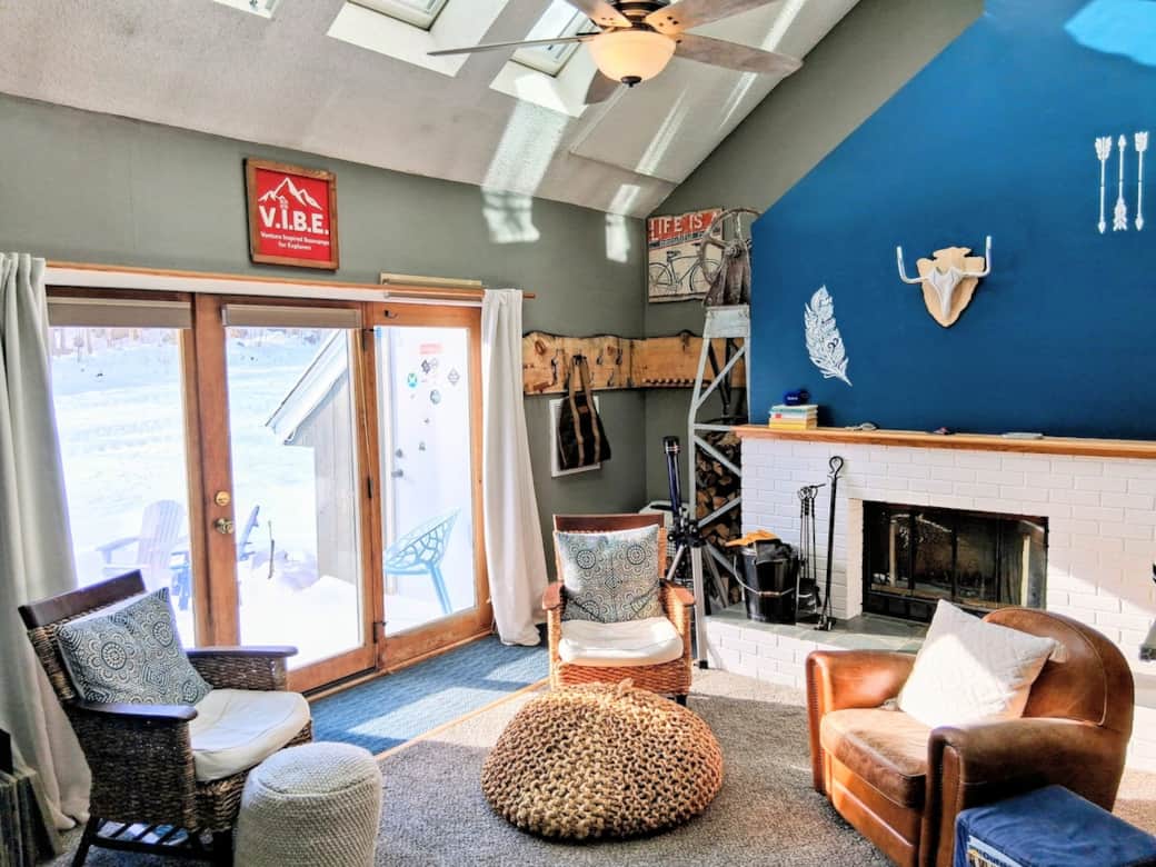 Sun-soaked seating surrounds a charming fireplace, perfect for après-ski evenings! Ski-In/Ski-Out right out the back deck.  Ski and coat racks in the corner for gear and firewood stacked in vintage ski tower.  
