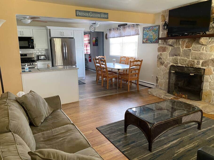 Living room with a large Roku TV, DVD player and two couches. (Fireplace is not functional)
