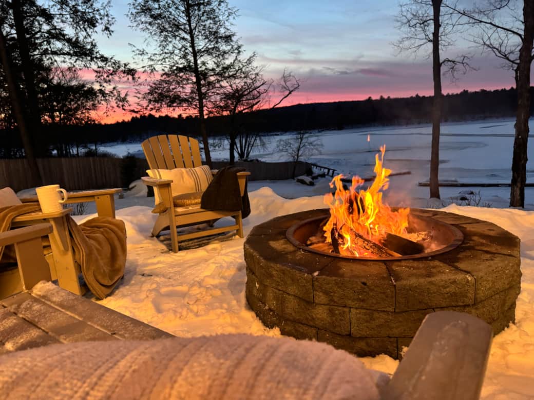 Warm up by the firepit with expansive views of the frozen lake.