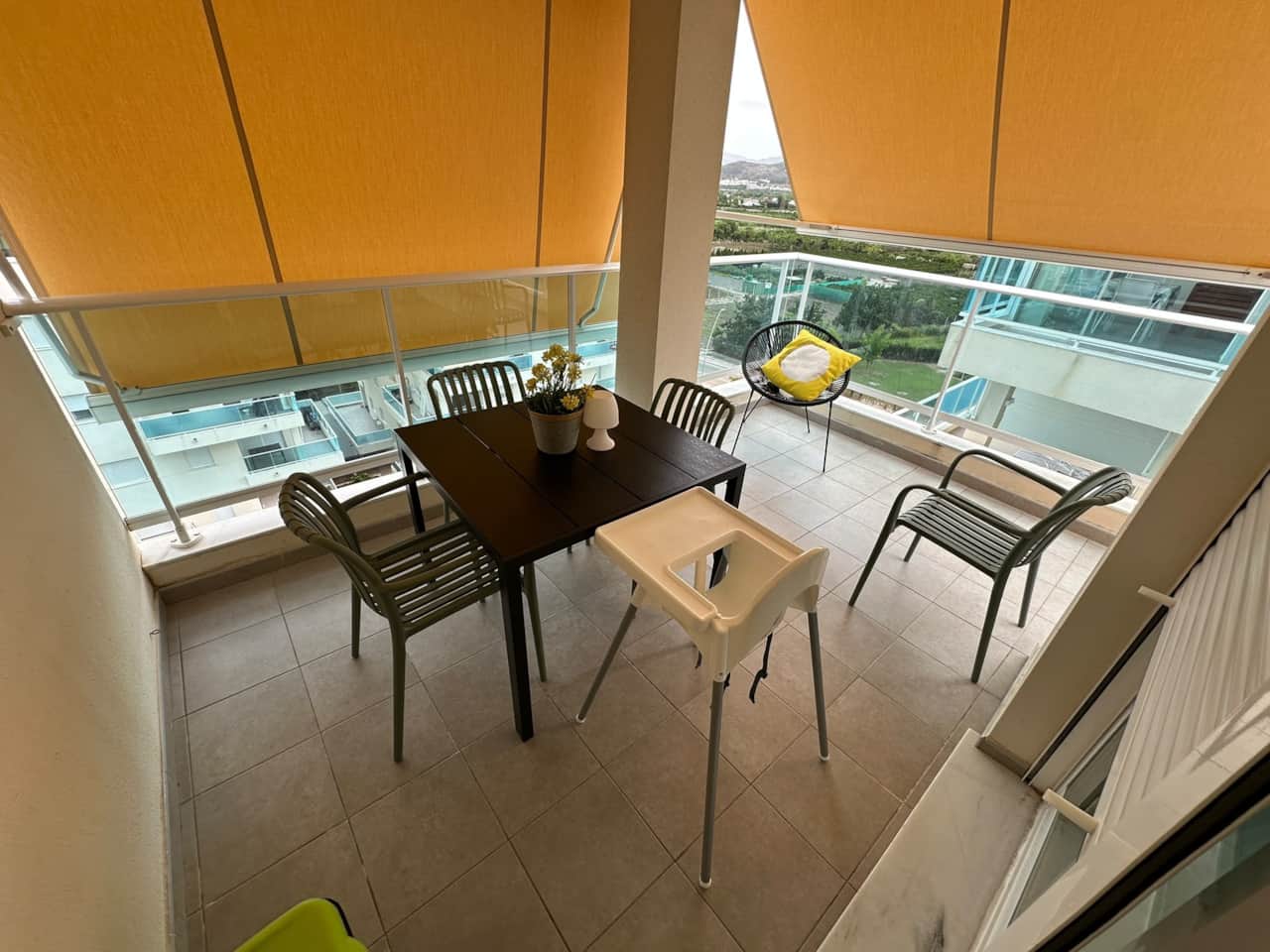 Terraza con toldo, mesa y sillas para comer fuera