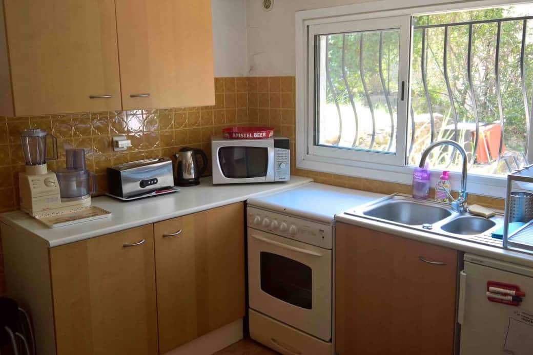 La cuisine est fonctionnelle avec gazinière, four, micro-ondes, grille pain, cafetière, cuiseur vapeur, ... et vue sur le jardin privatif