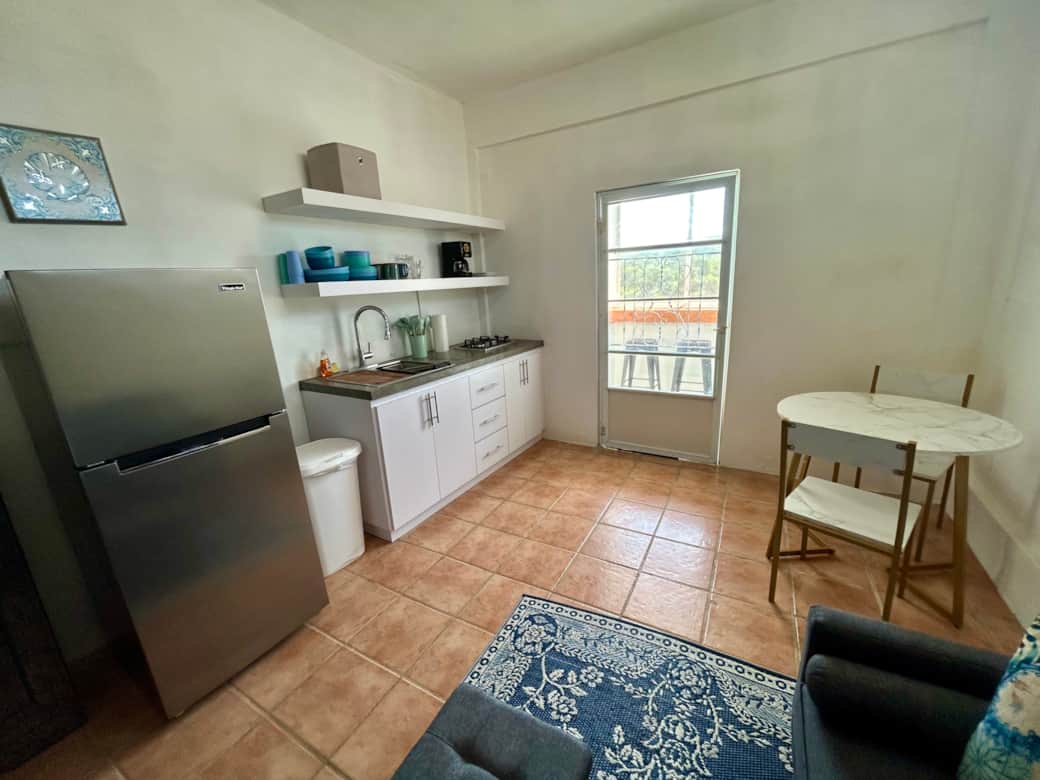 Kitchen with stove, full fridge, and dining table