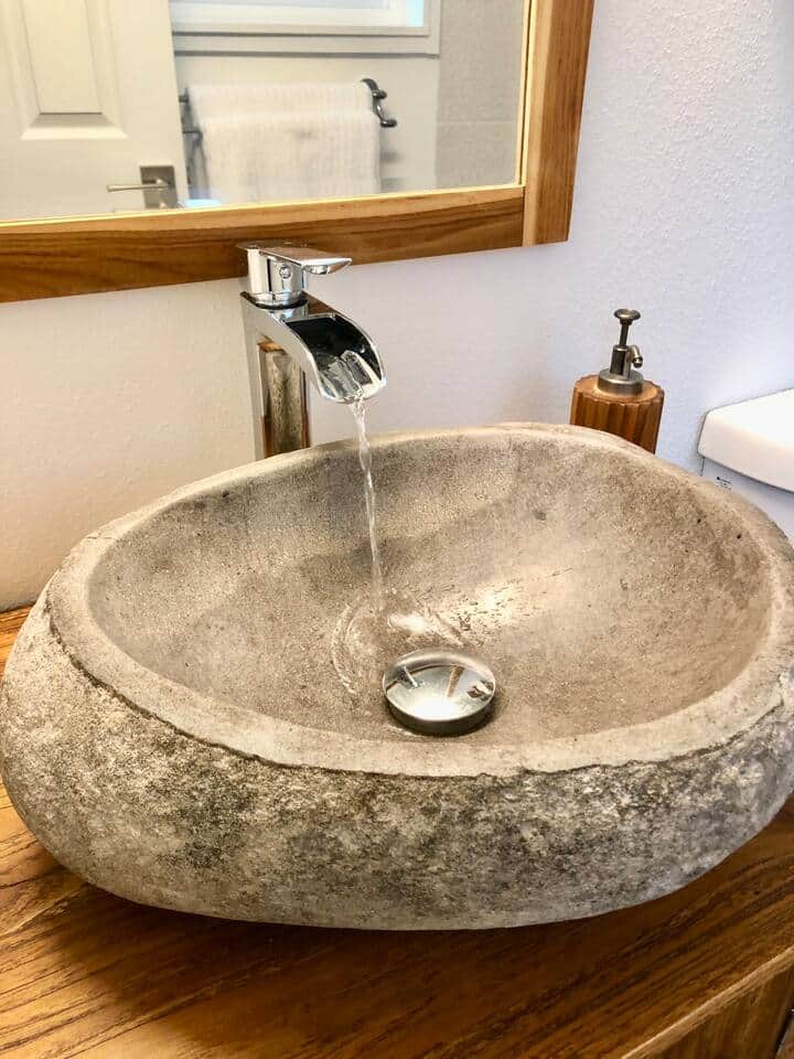 Waterfall faucet and natural teak vanity.