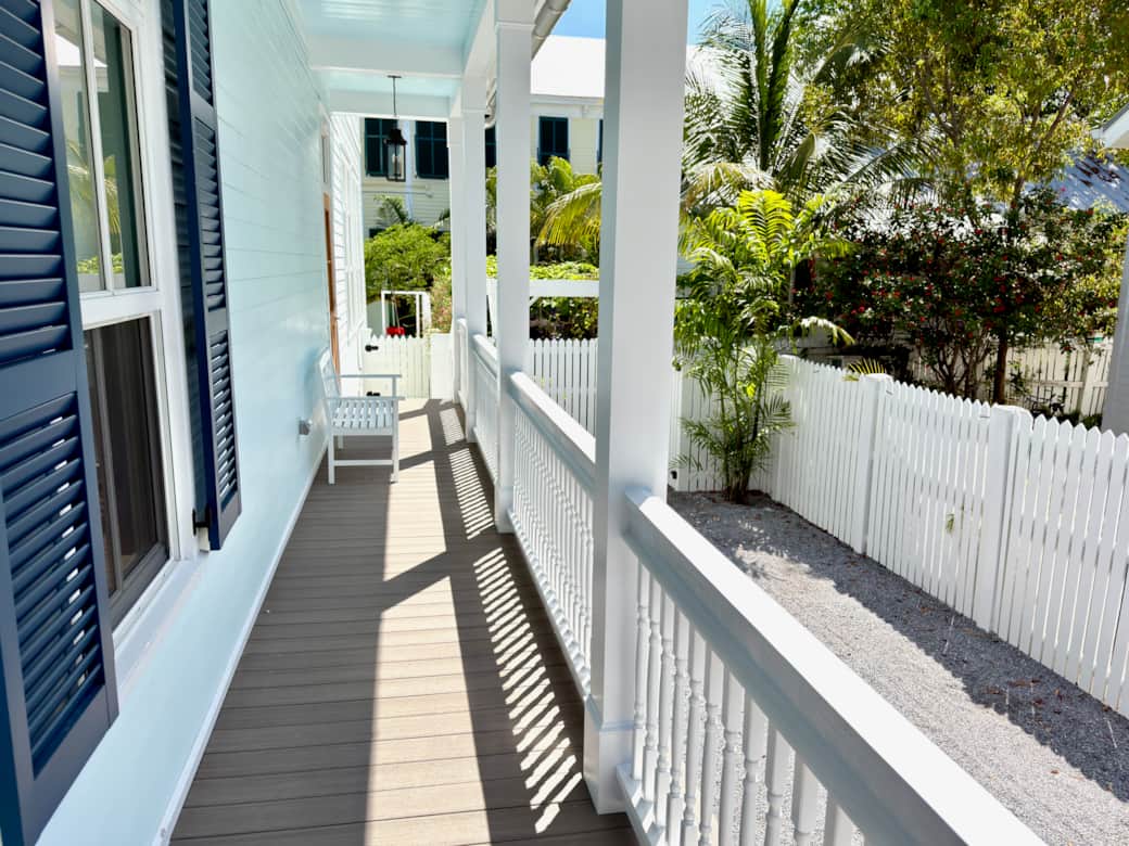 Classic Old Town Key West exterior with wraparound porches, tropical landscaping, and gated parking
